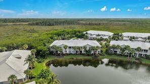 A resort with multiple buildings, a central water feature, and surrounding greenery. - HAWK'S NEST 202 - Luxurious Remodeled Fiddler's Creek Coach Home (Naples)