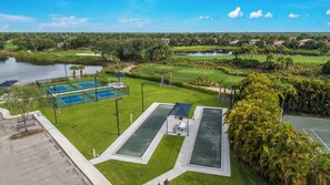 Un parcours de golf doté d’un court de tennis, d’une piscine et offrant une vue sur un quartier résidentiel.