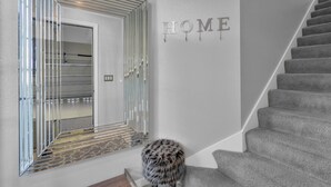 Una escalera con barandilla acolchada y un letrero en la pared que dice 'HOME'.
