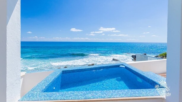 A swimming pool with a view of the ocean. - Casa Perla Suite 1 a 2 Bdrm Caribbean Oceanfront Condo w/ dipping pool (Isla Mujeres)