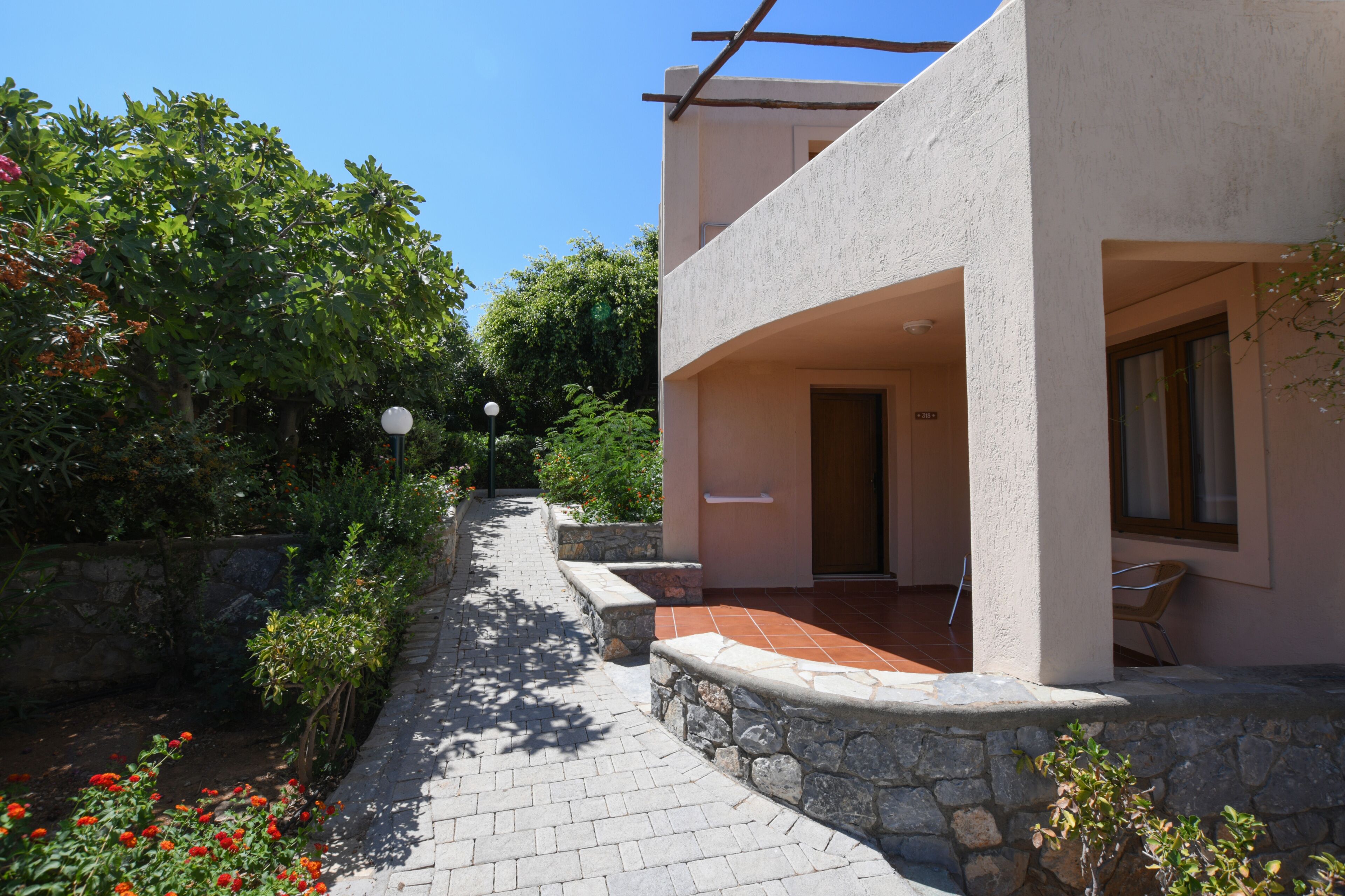 A modern two-story building with a stone pathway leading to a wooden door.