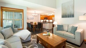 Una sala de estar con sofá, mesa de centro y comedor con sillas y mesa.