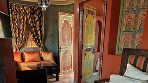 Une chambre d’hôtel avec un lit, un canapé, une petite table et un mur décoratif.