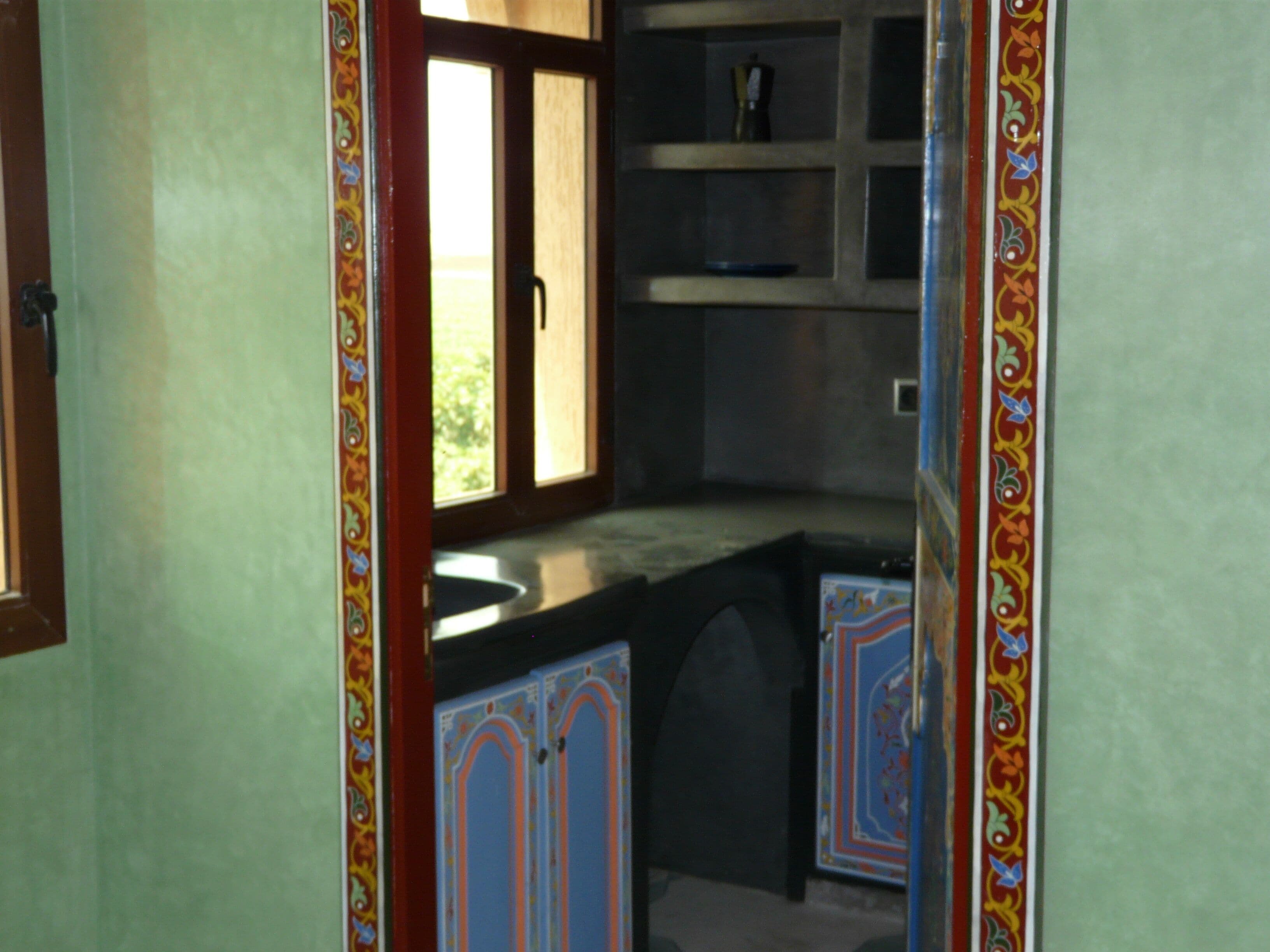 Una cocina con ventana, armarios y encimera.