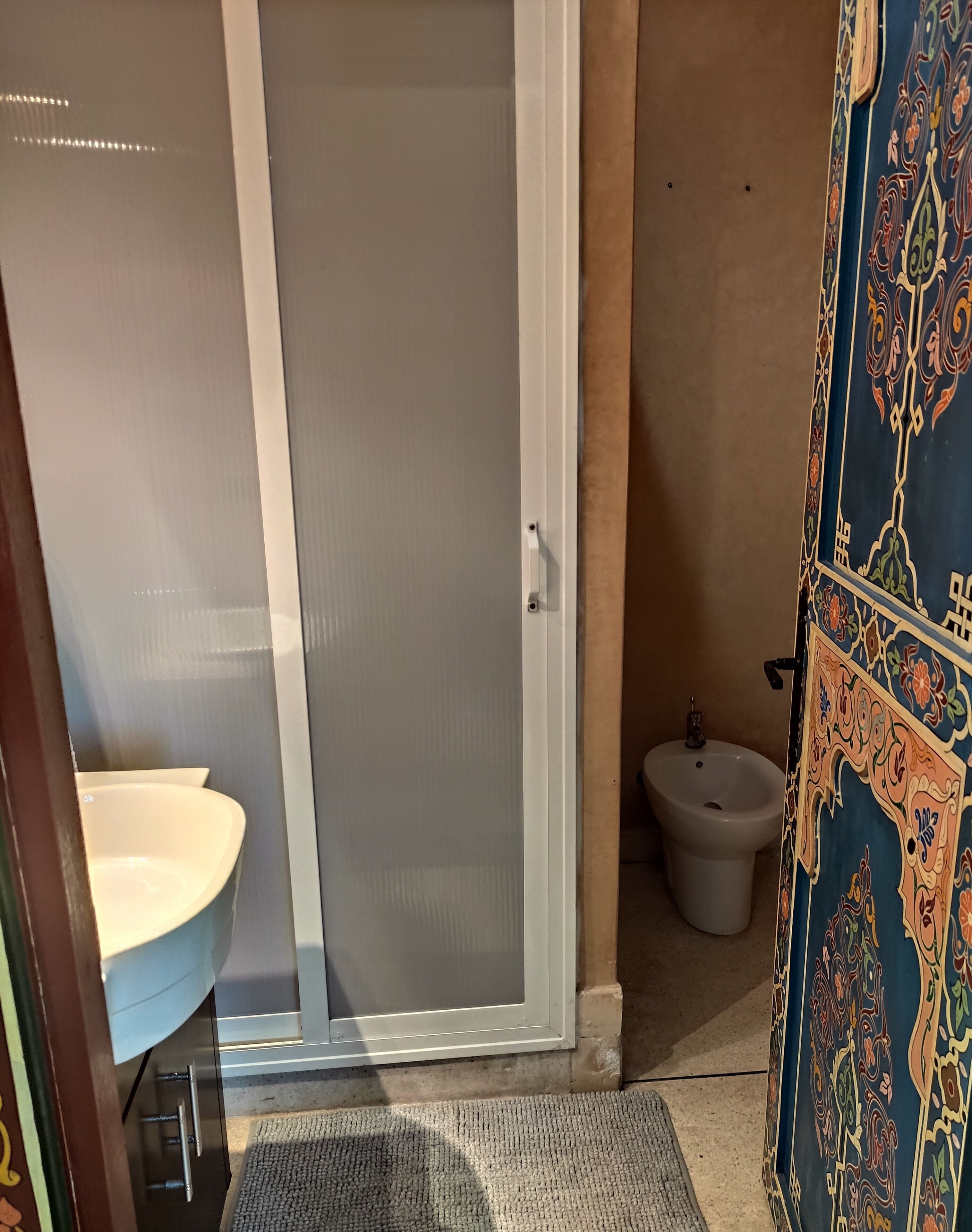A bathroom with a toilet, bidet, and a shower with a glass door.