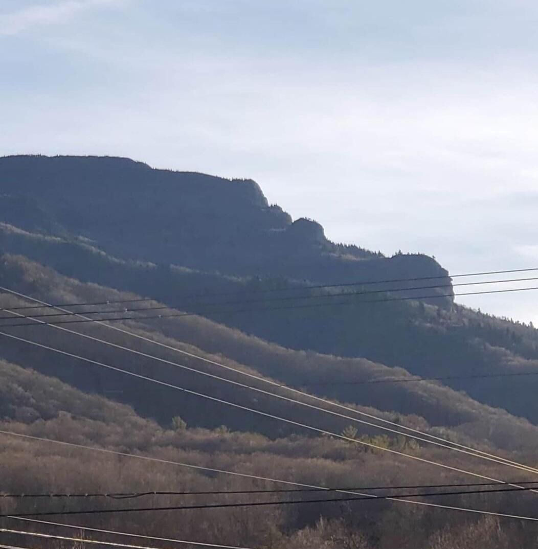 A mountainous landscape with power lines and sparse vegetation.