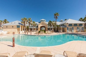 A pool area with lounge chairs and palm trees.