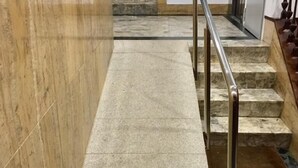 A marble staircase with metal railings leading to a door.