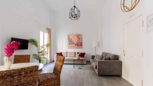 A modern living room with a sofa, two armchairs, a coffee table, and a TV mounted on the wall. - Sanlúcar de Barrameda  4 (Sanlucar de Barrameda)