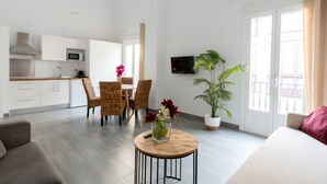 A modern apartment with a kitchen, dining area, and living room. It includes a TV, a potted plant, and a sofa. - Sanlúcar de Barrameda  4 (Sanlucar de Barrameda)