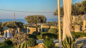 A landscaped garden with a view of the sea, a basketball hoop, and a white tent. - King Suite with privat jacuzzi (rethymno)