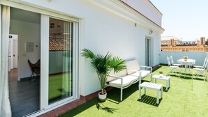 A balcony with a white sofa, a small table, and a potted plant. - Sanlúcar de Barrameda  7 (Sanlucar de Barrameda)