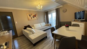 Una sala de estar moderna con un sofá, una mesa de comedor y un televisor.