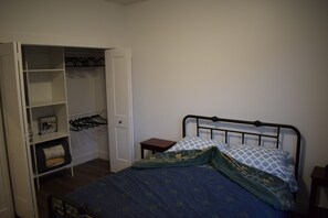 A bedroom with a bed, a wardrobe, and a nightstand.