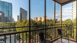 A balcony with a view of a cityscape, including tall buildings and trees. - Easy Walk to Downtown Attractions & WORLD CUP! (Atlanta)