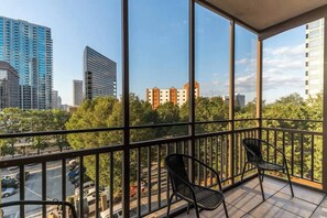 A balcony with a view of a cityscape, including tall buildings and trees. - Easy Walk to Downtown Attractions & WORLD CUP! (Atlanta)