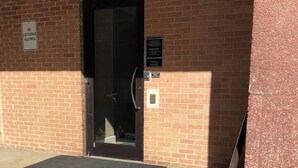 A brick building entrance with a door, a mat, and a sign indicating no loitering. - Easy Walk to Downtown Attractions & WORLD CUP! (Atlanta)