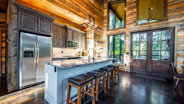 A spacious kitchen with a large island, wooden cabinetry, and a stainless steel refrigerator. - Somethin 2 Talk About ("S2TA") (McCurtain County)
