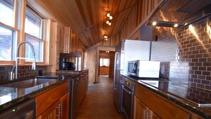 A modern kitchen with wooden cabinets, granite countertops, and stainless steel appliances. - Pointe of View on Otsego Lake. 4 Bedrooms, 4 Bathrooms, 6 miles from Cooperstown (Cooperstown)
