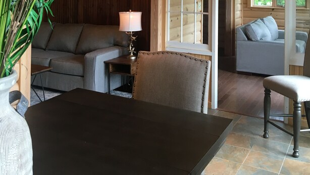A cozy cabin interior with a wooden ceiling, a dining table, a sofa, and a chair. - Pointe of View on Otsego Lake. 4 Bedrooms, 4 Bathrooms, 6 miles from Cooperstown (Cooperstown)