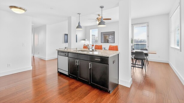 A modern kitchen with a central island, pendant lighting, and a dining area with a view. - Chic Boutique Condo in Nashvilles coveted 12 South Neighborhood Coffee Shops, Restaurants, Bars and Boutiques, just steps away. <br>Featuring plush linens , bath products and a balcony with free parking! (Nashville)