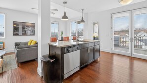 A modern kitchen with a central island, stainless steel appliances, and a large window providing natural light. - Chic Boutique Condo in Nashvilles coveted 12 South Neighborhood Coffee Shops, Restaurants, Bars and Boutiques, just steps away. <br>Featuring plush linens , bath products and a balcony with free parking! (Nashville)