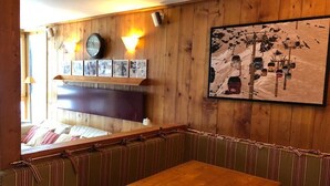Un interior de madera con una mesa de madera y asientos acolchados a rayas.