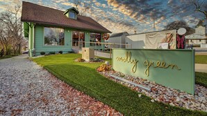 A building with a green sign reading "molly green" and a clear sky with clouds.