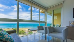 Habitació moderna amb un gran finestral que donar a una platja i l'oceà.