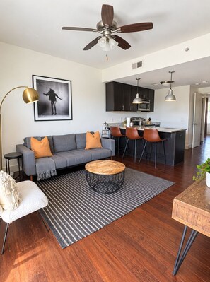 A modern living room with a sofa, coffee table, and a ceiling fan.