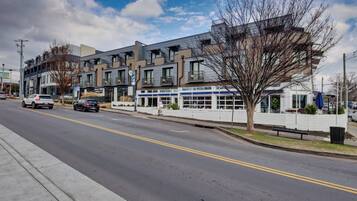 A multi-story building with a modern architectural style, featuring balconies and large windows.