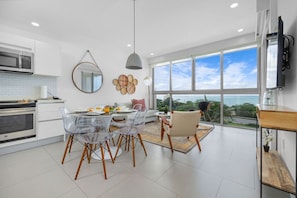 Enjoy ocean views from the kitchen and dining area, featuring an oven, microwave, and dining table with chairs.