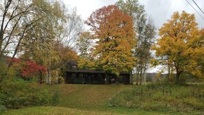 Ein rustikales Blockhaus, umgeben von Herbstlaub.