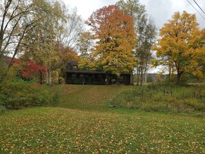 Ein rustikales Blockhaus, umgeben von Herbstlaub.