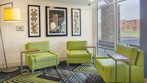 A hotel room with two green armchairs, a small table, a floor lamp, and three framed artworks on the wall. - Holiday Inn Express & Suites Abingdon by IHG (Abingdon)