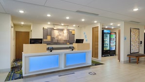 A reception area with a counter, digital check-in kiosks, a refrigerator, and a bench. - Holiday Inn Express & Suites Abingdon by IHG (Abingdon)