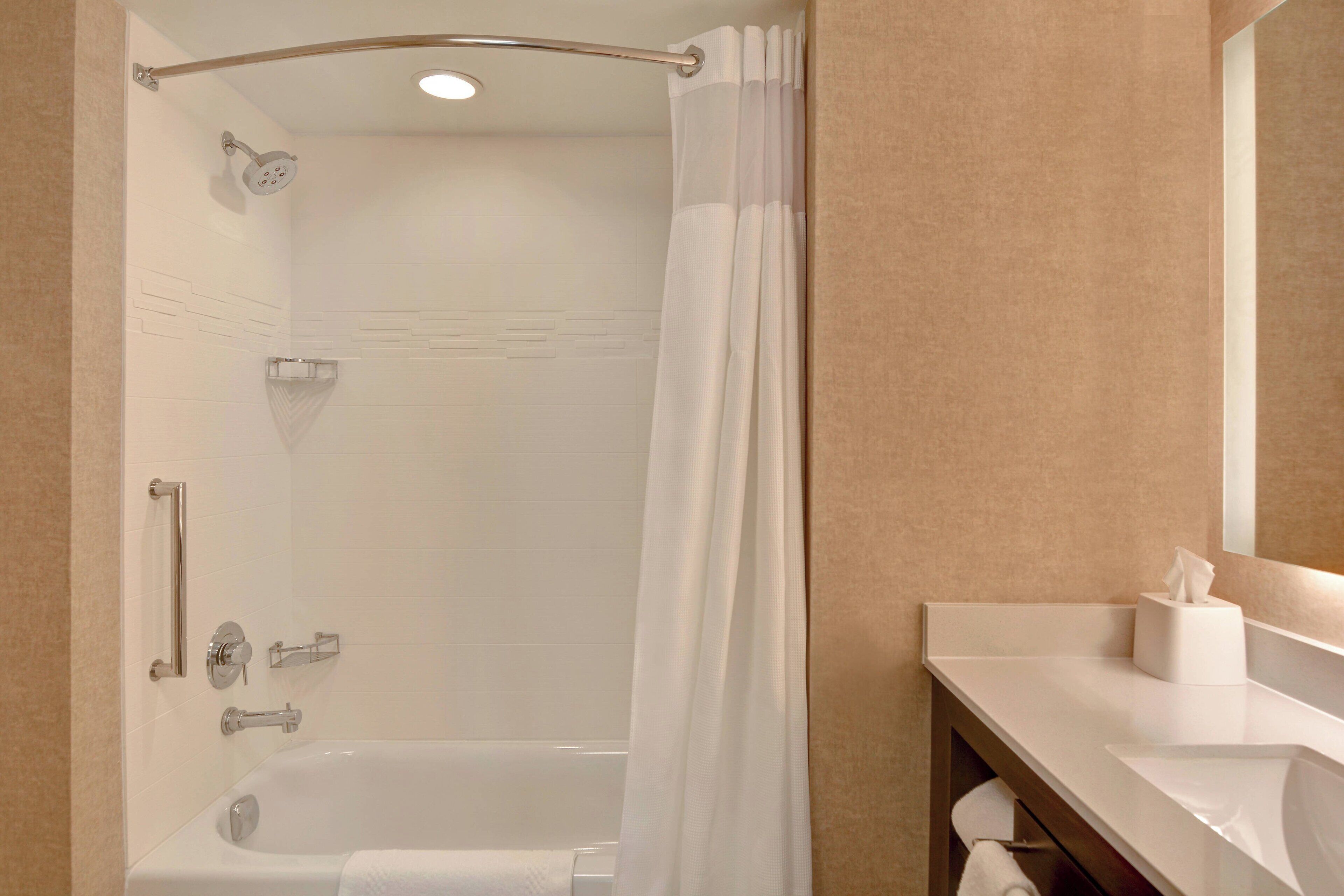 A modern bathroom with a walk-in shower, a bathtub, and a vanity with a mirror.