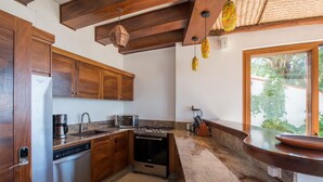 A kitchen with wooden cabinets, stainless steel appliances, and a stone countertop.