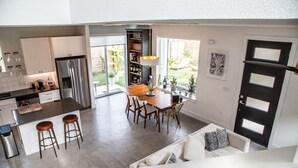 Una cucina moderna con zona pranzo, un divano e una scala che conduce a un altro livello.