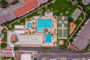 Oversigtsbillede af en ejendom med swimmingpool, tennisbaner og en basketballbane.