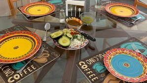 A dining table with colorful placemats, a central plate with avocado and onions, and a small bowl of salsa. - Walking Distance to Playa la Ropa  (Zihuatanejo)