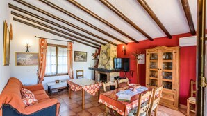 A cozy living room with a fireplace, wooden furniture, and a television. - El Ranchito de Martín Álora by Ruralidays (Málaga)
