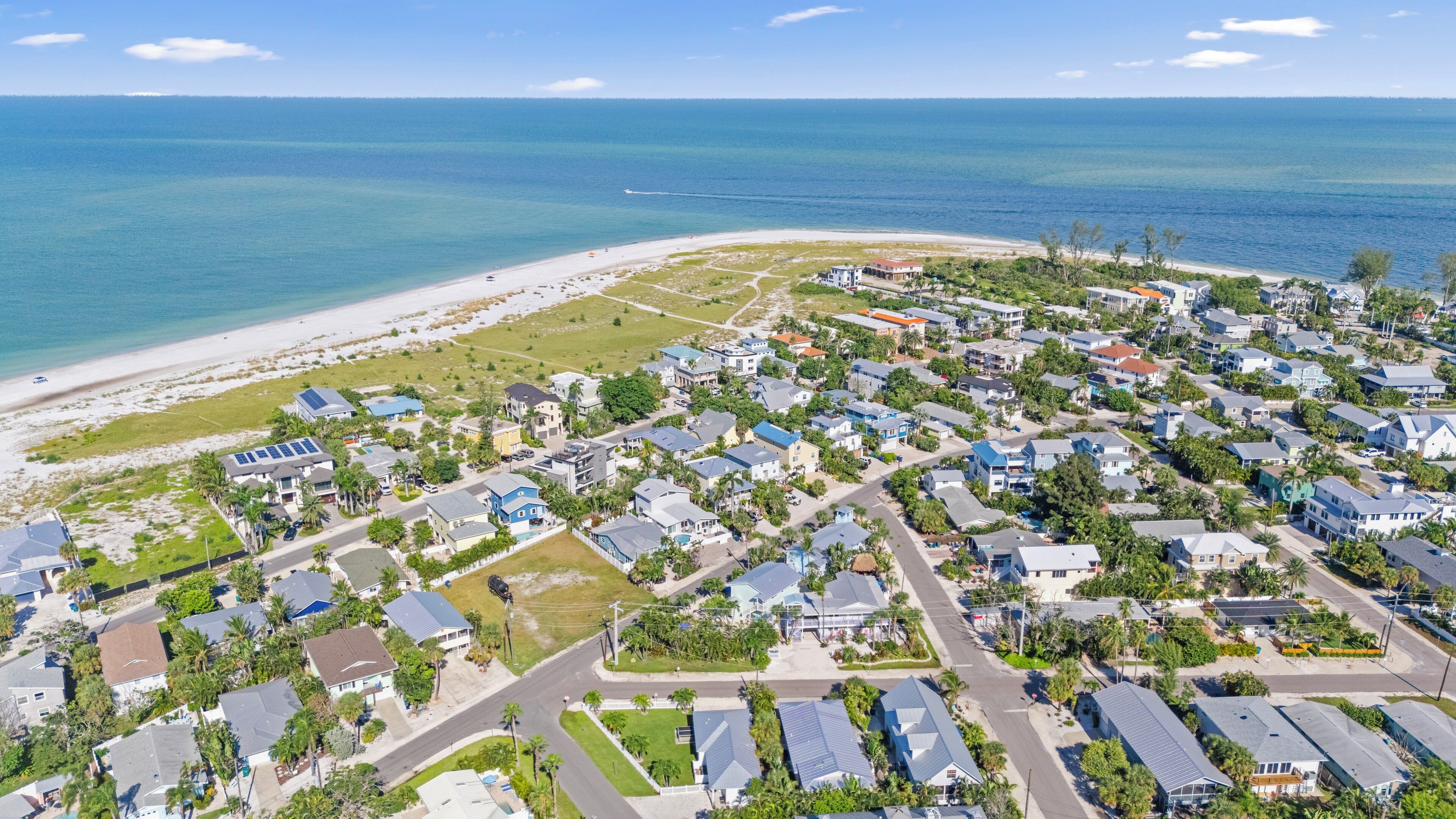 Luchtbeeld van een kustgebied met huizen, wegen en een strand.