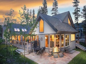 Een modern huis met een ruim terras, een open haard en een overdekte patio.