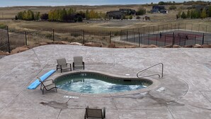A swimming pool with a 30-foot no diving sign, surrounded by a fence, with a view of mountains and a lake in the background. - Luxury lakeview cabin w/hot tub, pool, sports courts, pickleball, private beach! (Fish Haven)