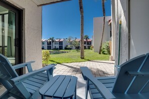 En uteplats med blå stolar och utsikt över ett bostadskomplex.