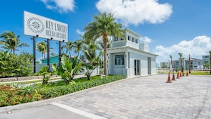 Der Eingang eines Resorts mit einem Schild, das "Key Largo Ocean Resort" zeigt, Palmen und einem gepflasterten Weg.