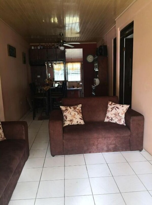 Cozy living space with a sofa, armchair, and dining area.