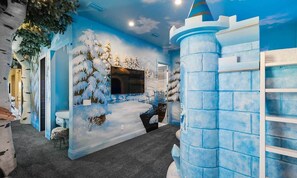 A room with a winter-themed mural, a television, and a castle-like structure. - Luxurious Mansion with Infinity Pool at Reunion (Kissimmee)