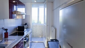 Una cocina moderna con un ventanal grande, horno empotrado y refrigerador.